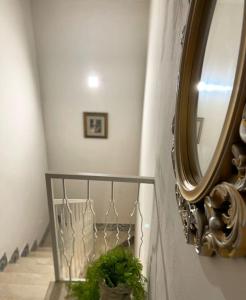a hallway with a mirror and a plant on a shelf at Igea Suite in Noto