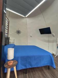 - une chambre avec un lit bleu et une table avec une lampe dans l'établissement Iglú Simbad con vista al cielo, à Barra de Navidad