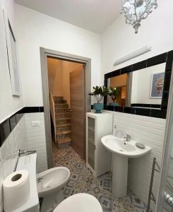 a bathroom with two toilets and a sink at Igea Suite in Noto