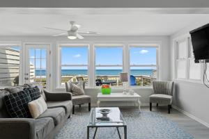 ein Wohnzimmer mit Sofa und Tisch in der Unterkunft Ocean Oasis Kure Beach Ocean front, Pool coming soon! in Kure Beach