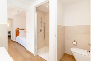 baño blanco con ducha y cama en Ginkgo - Familienfreundliches Appartment in Katalanischer Masia, en Sant Iscle de Vallalta