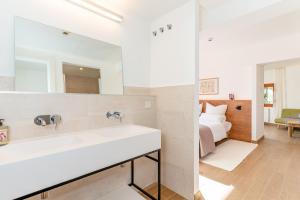 baño con lavabo y 1 cama en una habitación en Ginkgo - Familienfreundliches Appartment in Katalanischer Masia, en Sant Iscle de Vallalta