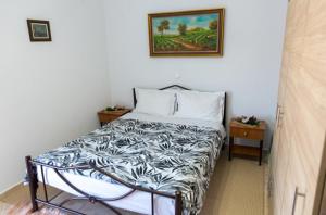 sypialnia z łóżkiem i zdjęciem na ścianie w obiekcie Stavroula's Houses w mieście Kélla