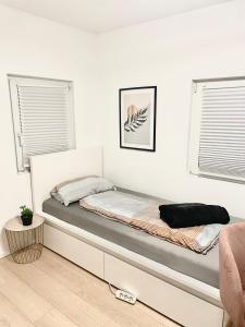 Bett in einem weißen Zimmer mit Bettrahmen in der Unterkunft Ein Zimmer Wohnung für zwei Personen Monteure geeignet in Linsengericht