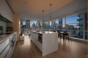 a kitchen and dining room with a view of the city at Luxury Corner Unit w Panoramic Tower & Downtown Skyline Views! FREE Banff Pass, Wine, Gym & Parking! in Calgary