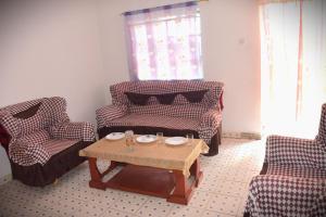 sala de estar con 2 sillas y mesa de centro en Olgosua Homestay Maasai Mara en Sekenani