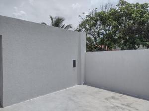 a white fence with trees in the background at top Suites in Saquarema