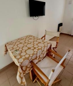 een tafel en stoelen in een kamer met een televisie bij Aires del Centro in Alta Gracia