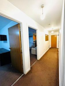 Zimmer mit einem Zimmer mit einem Bett und einer Tür in der Unterkunft Luxury 2 beds Apartment with 2 bathrooms, living dining & Parking - East London in Barkingside