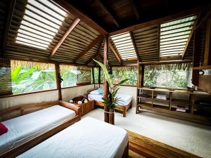 a bedroom with two beds in a room with windows at Casa Vida Verde in Cabo Matapalo