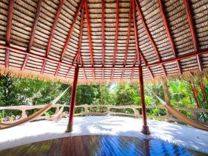 a hammock in a straw hut with a pool at Casa Vida Verde in Cabo Matapalo