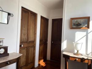 a hallway with two wooden doors and a clock on the wall at Résidence -pleneuf Val Andre - Maisons & Villas 604 in Pléneuf-Val-André