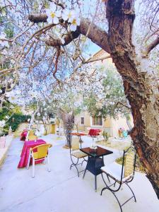 eine Terrasse mit einem Tisch und Stühlen unter einem Baum in der Unterkunft Riad Kasbah des Roches in Akhendachou nʼAït Ouffi