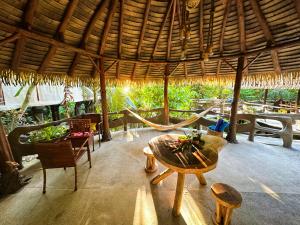 a room with a table and chairs and a straw roof at Casa Vida Verde in Cabo Matapalo
