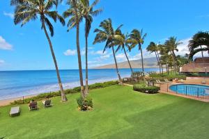 a resort yard with palm trees and a swimming pool at Kihei Beach Resort 608 in Kihei