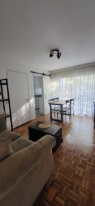 uma sala de estar com um sofá e uma mesa em apto 1 dorm sobre Ellauri em Montevidéu