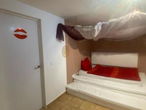 - une chambre avec un lit doté d'oreillers rouges et une fenêtre dans l'établissement TantraXtreme, à Aguatona