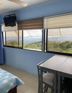 Zimmer mit einem Tisch und einem Fenster mit Aussicht in der Unterkunft Cabaña2 Mirador Jacuzzi in Sarchí
