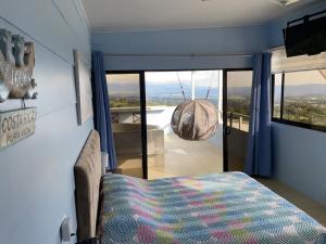 Schlafzimmer mit einem Bett und einem großen Glasfenster in der Unterkunft Cabaña2 Mirador Jacuzzi in Sarchí