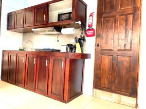 eine Küche mit Holzschränken und einer Tür in der Unterkunft Cabaña2 Mirador Jacuzzi in Sarchí
