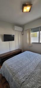 um quarto com uma cama grande e uma janela em apto 1 dorm sobre Ellauri em Montevidéu