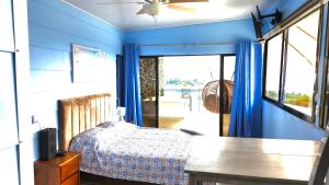 Schlafzimmer mit einem Bett mit blauen Wänden und einem Fenster in der Unterkunft Cabaña2 Mirador Jacuzzi in Sarchí