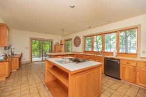 a large kitchen with wooden cabinets and a black dishwasher at Wake N Lake in Littleton