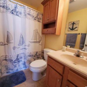 a bathroom with a toilet and a sink and a shower curtain at Beachy Condo right on Oceanfront in Myrtle Beach