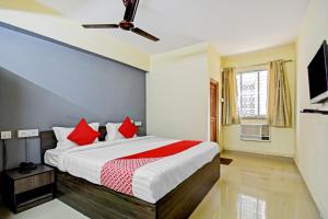 1 dormitorio con 1 cama grande con almohadas rojas en OYO Flagship Oblivion Stays en Bālihāti