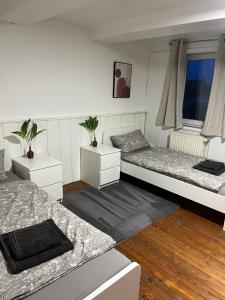 Zimmer mit 2 Betten und 2 Tischen in der Unterkunft Weber Apartment David in Bramsche