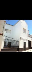 um edifício branco com uma cerca em frente em Hostal Los Amigos em Siruela