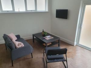 - un salon avec un canapé, une table et une télévision dans l'établissement Beautiful New built 2 bedroom apartment, à Purley
