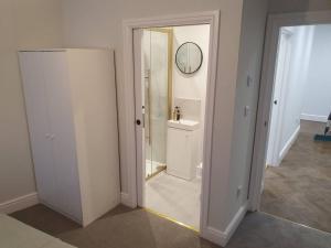 La salle de bains blanche est pourvue d'un lavabo et d'un miroir. dans l'établissement Beautiful New built 2 bedroom apartment, à Purley