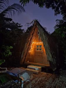 una cabaña con techo de paja con luces encendidas en Cabaña LunAzul, en San Antero