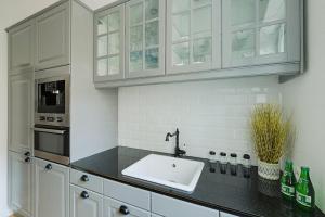 a kitchen with a sink and white cabinets at TOP Place*Unique Royal Route View*4 Bedrooms*6Beds in Warsaw
