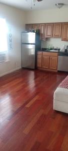 a kitchen with wooden floors and a stainless steel refrigerator at the rest spot in Schenectady +13 photos