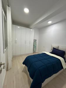 1 dormitorio con 1 cama azul y armarios blancos en New Bazar Retreat Apartment, en Tirana