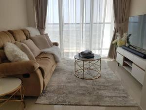 a living room with a couch and a television at Cosy 1 bedroom in Damac Hills in Dubai