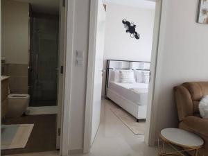 a bedroom with a bed and a walk in shower at Cosy 1 bedroom in Damac Hills in Dubai