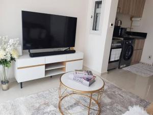 a living room with a tv and a coffee table at Cosy 1 bedroom in Damac Hills in Dubai