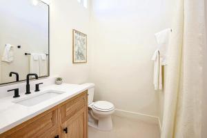 a white bathroom with a sink and a toilet at Downtown Kokopelli West 4 - Newly Remodeled Stylish Studio in Moab