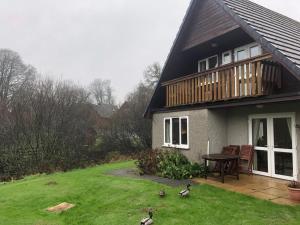 a house with a table and some birds in the yard at Cosy 3 Bed lodge on 35 acre Holiday Estate in Bodmin