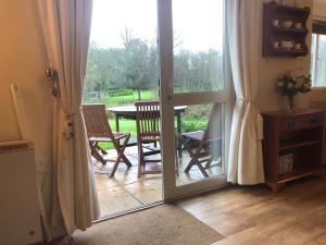 an open door to a patio with a table and chairs at Cosy 3 Bed lodge on 35 acre Holiday Estate in Bodmin