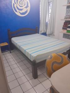 Cama en habitación con pared azul en Hostel da Socorro en Recife