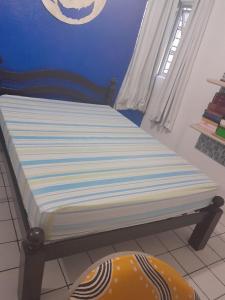 uma cama num quarto com uma parede azul em Hostel da Socorro em Recife