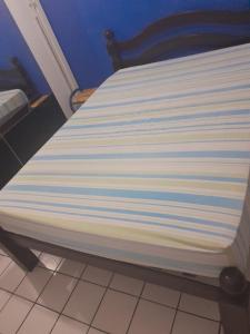 a white bed with blue and white stripes on it at Hostel da Socorro in Recife