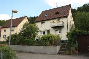 ein weißes Haus mit braunem Dach in der Unterkunft Ferienwohnung kleines Lautertal in Herrlingen