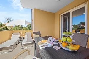 una mesa con una bandeja de fruta en el balcón en Apartment Dreams, en Fažana
