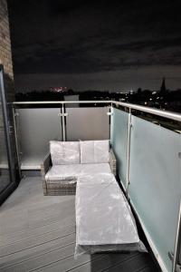 eine Bank auf dem Balkon eines Gebäudes in der Unterkunft Queens Luxury Apartments Wembley Stadium - London in London