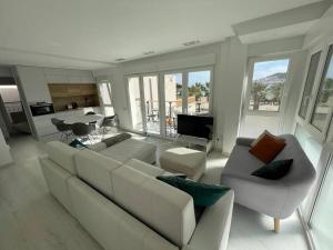 a living room with a white couch and chairs at LF LEVEL San José in San José